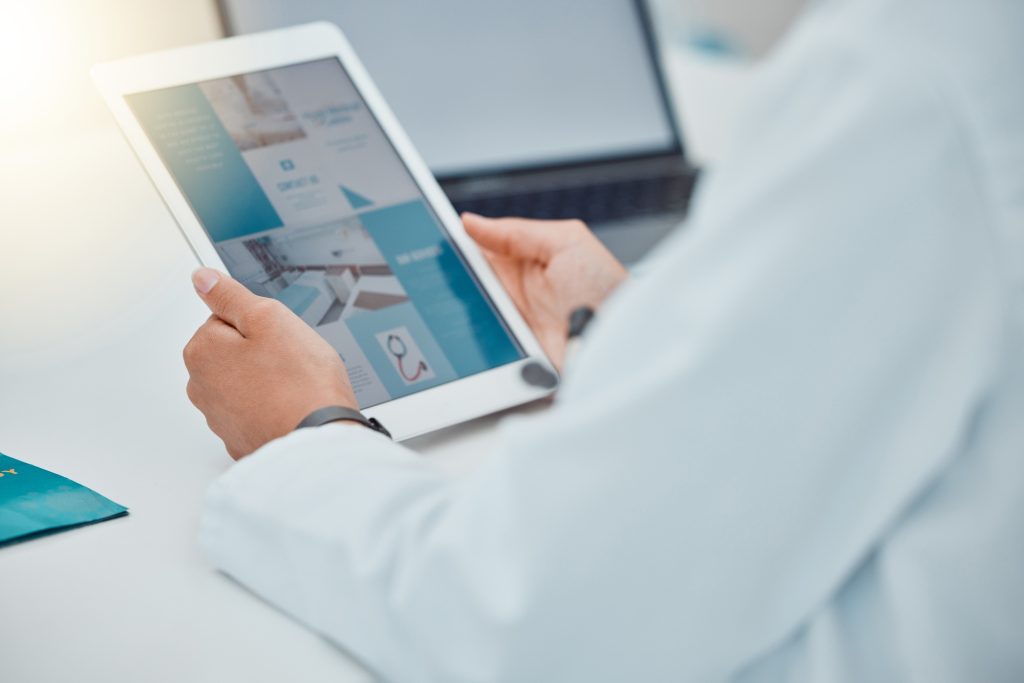 Doctor using a tablet for research on medical website for medical equipment. Healthcare worker with