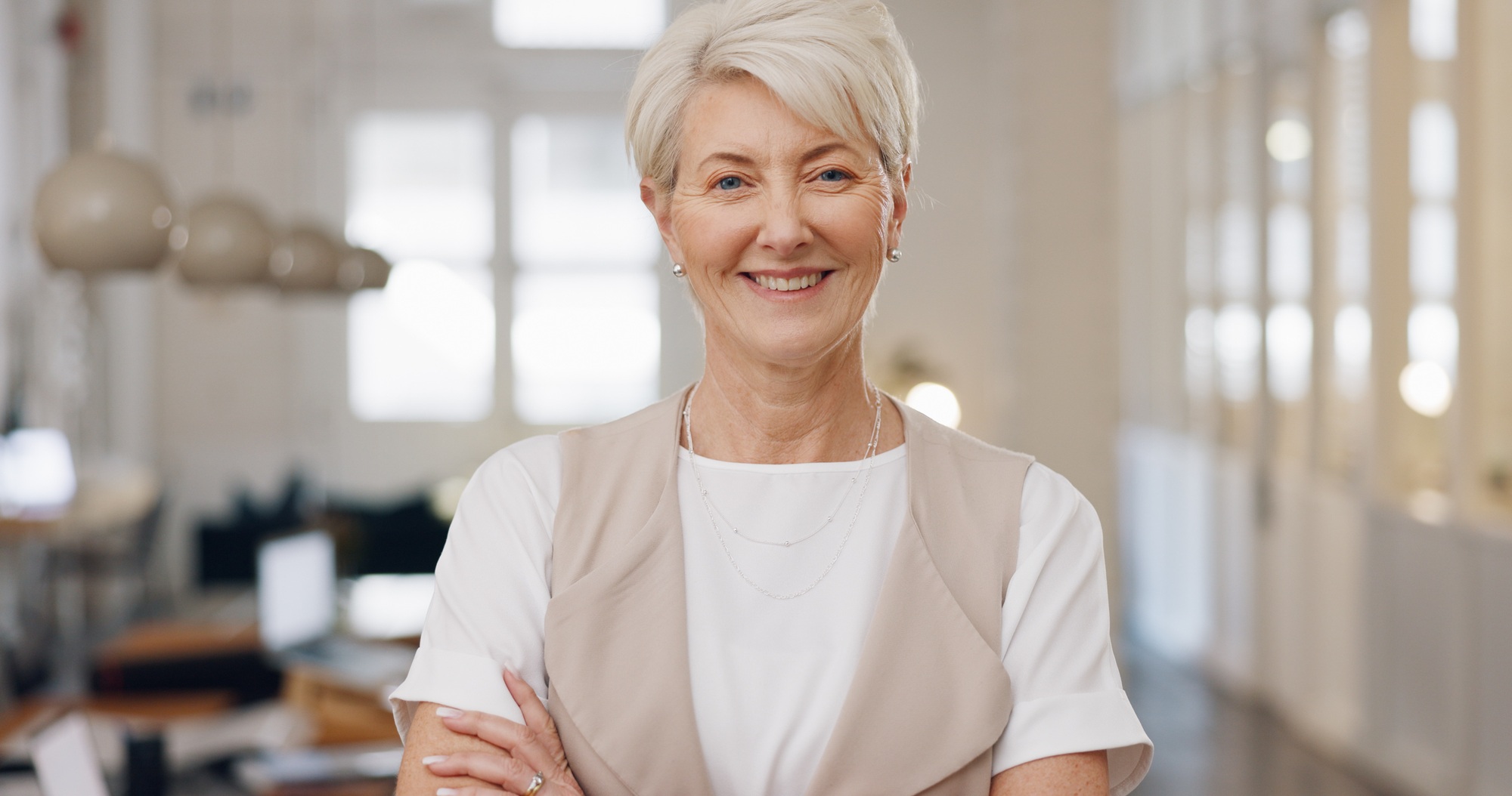 Elderly woman, face and smile with arms crossed for corporate leadership, management or vision at o